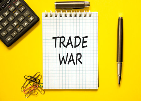 Trade war symbol. Concept word Trade war on beautiful white note. Black calculator. Black pen. Beautiful yellow paper background. Business trade war concept. Copy space.の写真素材