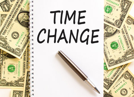 Time change symbol. Concept word Time change on beautiful white note. Dollar bills. Beautiful dollar bills background. Black pen. Business time change concept. Copy space.の写真素材