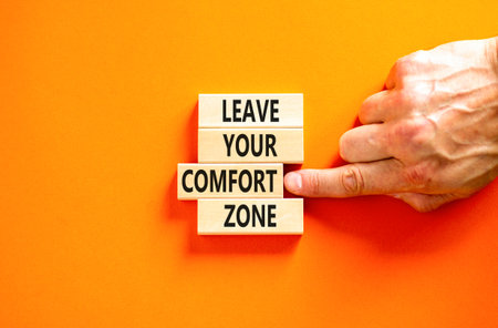 Leave your comfort zone symbol. Concept words Leave your comfort zone on beautiful wooden blocks. Beautiful orange paper background. Business psychological Leave your comfort zone concept. Copy space.の写真素材