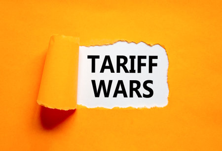 Trade tariff wars symbol. Concept word Tariff wars on beautiful white paper. Beautiful orange paper background. Business trade tariff wars concept. Copy space.の写真素材