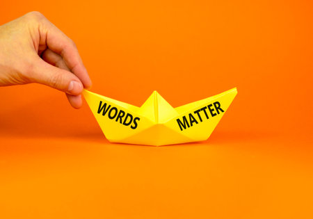 Words matter symbol. Concept word Words matter on beautiful yellow paper boat. Businessman's hand. Beautiful orange paper background. Business words matter concept. Copy space.の写真素材