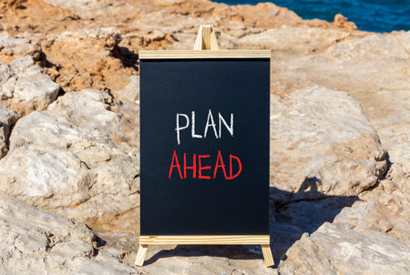 Plan ahead symbol. Concept word Plan ahead on beautiful black blackboard. Beautiful stone and blue sea sky background. Black blackboard. Business plan ahead concept. Copy space.の写真素材
