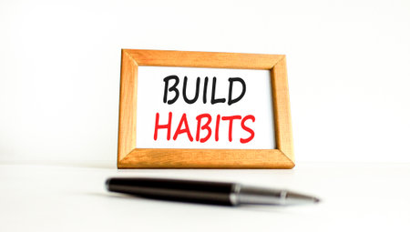 Build habits symbol. Concept word Build habits on beautiful wooden picture frame. Black pen. Beautiful white paper background. Business build habits concept. Copy space.の写真素材