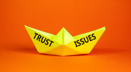 Trust issues symbol. Concept word Trust issues on beautiful yellow paper boat. Beautiful orange paper background. Business trust issues concept. Copy space.の写真素材