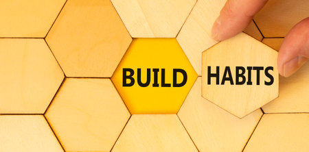Build habits symbol. Concept word Build habits on beautiful wooden puzzles. Businessman's hand....