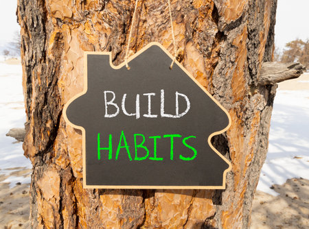 Build habits symbol. Concept word Build habits on beautiful black blackboard. Beautiful old pine tree background. Black blackboard. Business build habits concept. Copy space.の写真素材