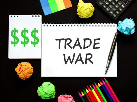Trade war symbol. Concept word Trade war on beautiful white note. Black calculator. Black pen. Beautiful black paper background. Business trade war concept. Copy space.の写真素材
