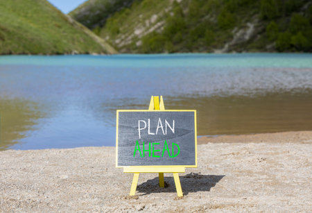 Plan ahead symbol. Concept word Plan ahead on beautiful black blackboard. Beautiful mountain lake sand beach background. Black blackboard. Business plan ahead concept. Copy space.の写真素材