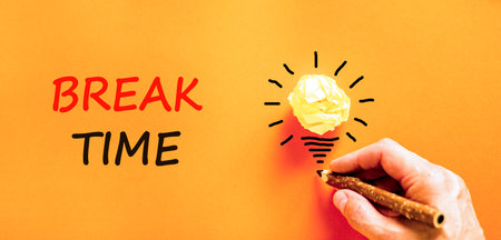 Break time symbol. Concept Break word time on beautiful orange paper. Businessman's hand. Light bulb icon. Beautiful orange paper background. Business break time concept. Copy space.の写真素材