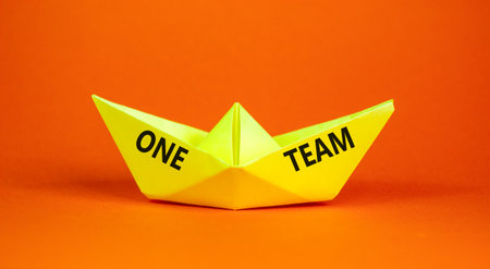 One team symbol. Concept word One team on beautiful yellow paper boat. Beautiful orange paper background. Business one team concept. Copy space.の写真素材
