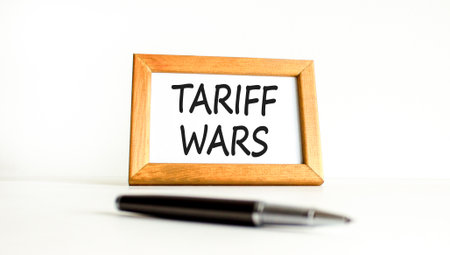 Trade tariff wars symbol. Concept word Tariff wars on beautiful wooden picture frame. Black pen. Beautiful white paper background. Business trade tariff wars concept. Copy space.の写真素材