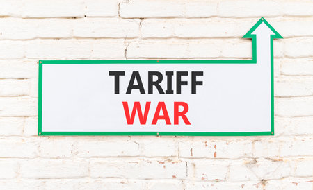 Trade tariff war symbol. Concept word Tariff war on beautiful white sign on white brick wall. Beautiful white brick wall background. Business trade tariff wars concept. Copy space.の写真素材