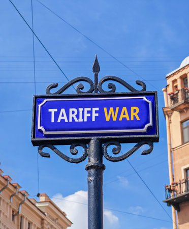 Trade tariff war symbol. Concept word Tariff war on beautiful blue road sign. Beautiful blue sky and buildings background. Business trade tariff wars concept. Copy space.の写真素材
