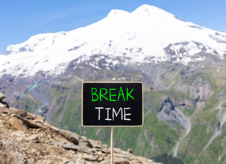 Break time symbol. Concept Break word time on beautiful black blackboard. Beautiful stone mountain Elbrus blue sky background. Black blackboard. Business break time concept. Copy space.の写真素材