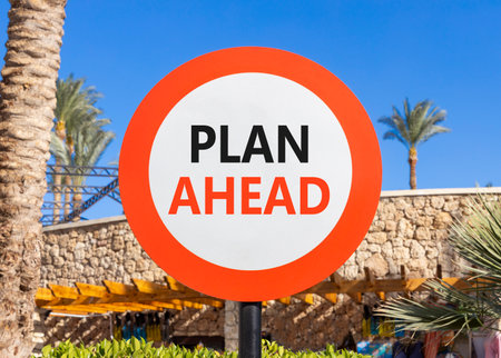 Plan ahead symbol. Concept word Plan ahead on beautiful red and white road sign. Beautiful palm tree and market blue sky background. Business plan ahead concept. Copy space.の写真素材