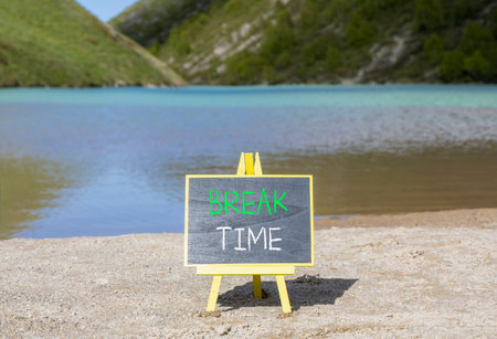 Break time symbol. Concept Break word time on beautiful black blackboard. Beautiful mountain lake sand beach background. Black blackboard. Business break time concept. Copy space.の写真素材