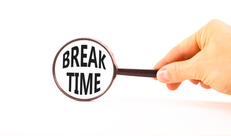 Break time symbol. Concept Break word time on beautiful magnifying glass. Businessman's hand. Beautiful white paper background. Black magnifying glass. Business break time concept. Copy space.の写真素材