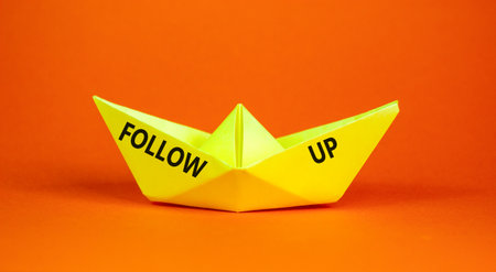 Follow up symbol. Concept word Follow up on beautiful yellow paper boat. Beautiful orange paper background. Business follow up concept. Copy space.の写真素材