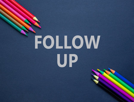 Follow up symbol. Concept word Follow up on beautiful black paper. Colored pencils. Beautiful black paper background. Business follow up concept. Copy space.の写真素材