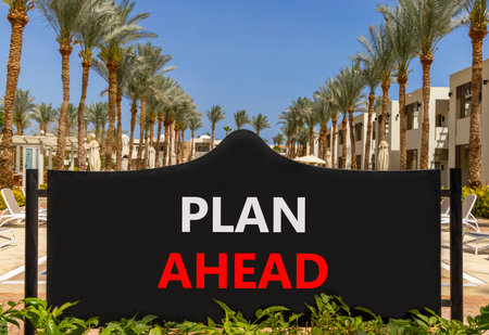 Plan ahead symbol. Concept word Plan ahead on beautiful black road sign. Beautiful palm trees and blue sky background. Business plan ahead concept. Copy space.の写真素材