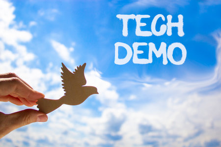 Tech demo symbol. Concept word Tech demo on beautiful blue sky. Businessman's hand with wooden bird. Beautiful blue sky and cloud background. Business tech demo concept. Copy space.の写真素材