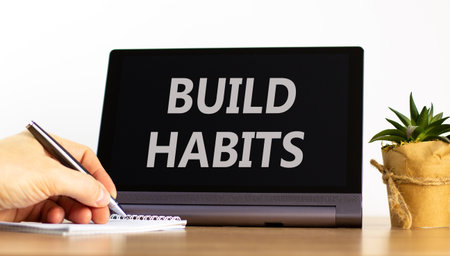 Build habits symbol. Concept word Build habits on beautiful black tablet. Businessman's hand with pen. Calculator. Beautiful white background. Business build habits concept. Copy space.の写真素材