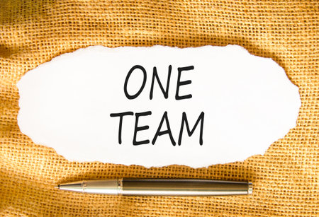 One team symbol. Concept word One team on beautiful white paper. Beautiful canvas background. Black pen. Business one team concept. Copy space.の写真素材