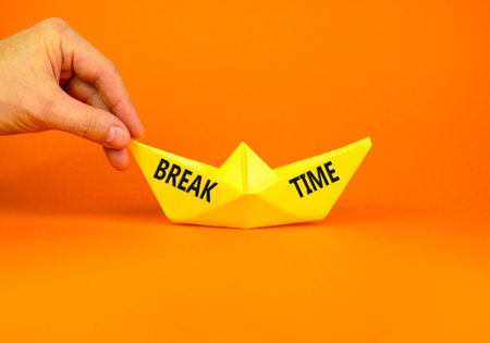 Break time symbol. Concept Break word time on beautiful yellow paper boat. Businessman's hand. Beautiful orange paper background. Business break time concept. Copy space.の写真素材