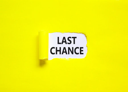 Last chance symbol. Concept word Last chance on beautiful white paper. Beautiful yellow paper background. Business last chance concept. Copy space.の写真素材