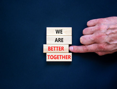 We are better together symbol. Concept words phrase We are better together on beautiful wooden blocks. Beautiful black background. Businessman hand. Business We are better together concept. Copy spaceの写真素材