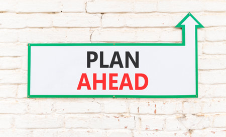 Plan ahead symbol. Concept word Plan ahead on beautiful white sign on white brick wall. Beautiful white brick wall background. Business plan ahead concept. Copy space.の写真素材