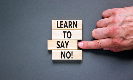 Learn to say no symbol. Concept words phrase Learn to say no on beautiful wooden blocks. Beautiful gray paper background. Businessman's hand. Business psychological Learn to say no concept. Copy spaceの写真素材