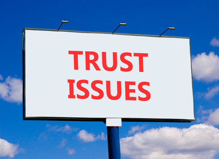 Trust issues symbol. Concept word Trust issues on beautiful white billboard. Beautiful blue sky and clouds background. Business trust issues concept. Copy space.の写真素材