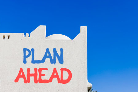 Plan ahead symbol. Concept word Plan ahead on beautiful white wall. Beautiful blue sky background. Business plan ahead concept. Copy space.の写真素材