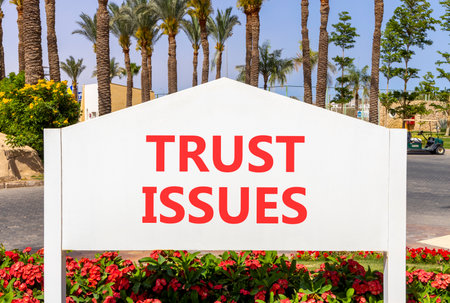 Trust issues symbol. Concept word Trust issues on beautiful white billboard. Beautiful blue sky and...