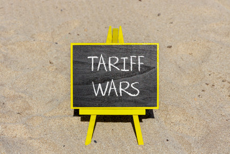 Trade tariff wars symbol. Concept word Tariff wars on beautiful black blackboard. Beautiful sand beach background. Black blackboard. Business trade tariff wars concept. Copy space.の写真素材
