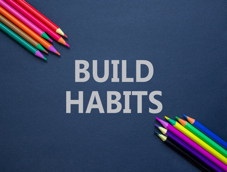 Build habits symbol. Concept word Build habits on beautiful black paper. Colored pencils. Beautiful black paper background. Business build habits concept. Copy space.