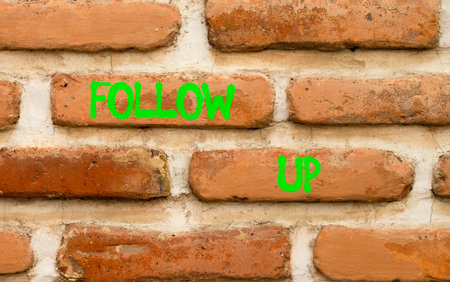 Follow up symbol. Concept word Follow up on beautiful old brown brick wall. Beautiful old brown...