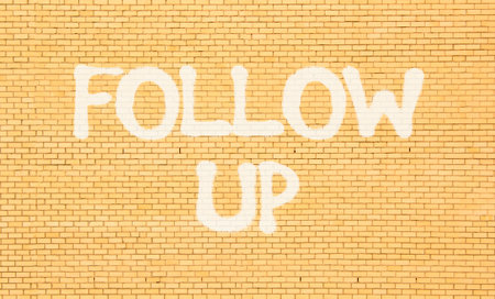 Follow up symbol. Concept word Follow up on beautiful brown brick wall. Beautiful brown brick wall background. Brick wall Business follow up concept. Copy space.の写真素材