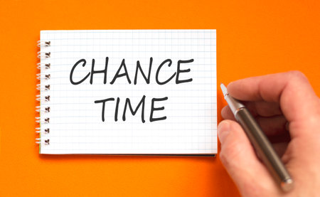 Chance time symbol. Concept word Chance time on beautiful white note. Businessman's hand with pen. Beautiful orange paper background. Business chance time concept. Copy space.の写真素材