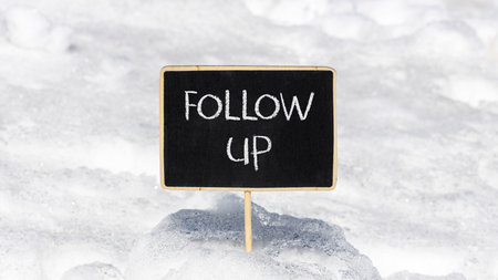 Follow up symbol. Concept word Follow up on beautiful black blackboard. Beautiful white snow...
