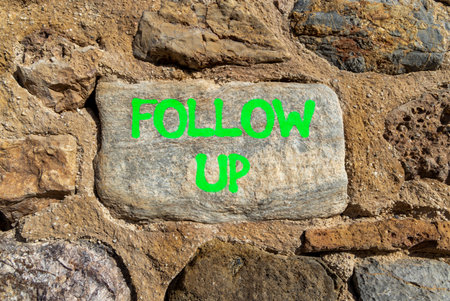 Follow up symbol. Concept word Follow up on beautiful gray stone on stone wall. Beautiful stone wall...