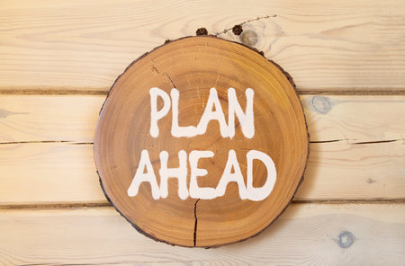 Plan ahead symbol. Concept word Plan ahead on beautiful wooden circle on wooden wall. Beautiful wooden wall background. Business plan ahead concept. Copy space.の写真素材