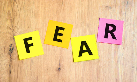Fear symbol. Concept word Fear on beautiful colored paper. Beautiful wooden table wooden background. Business, lifestyle and fear concept. Copy space.の写真素材