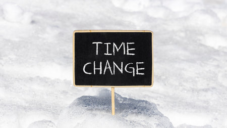Time change symbol. Concept word Time change on beautiful black blackboard. Beautiful white snow...