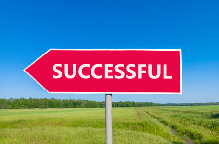 Successful symbol. Concept word Successful on beautiful red road sign. Beautiful blue sky green...