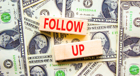 Follow up symbol. Concept word Follow up on beautiful wooden blocks. Dollar bills. Beautiful dollar bills background. Business follow up concept. Copy space.の写真素材