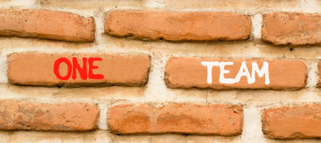 One team symbol. Concept word One team on beautiful old brown brick wall. Beautiful old brown brick...