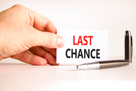 Last chance symbol. Concept word Last chance on beautiful white card. Beautiful black pen. Beautiful white paper background. Businessman's hand. Business last chance concept. Copy space.