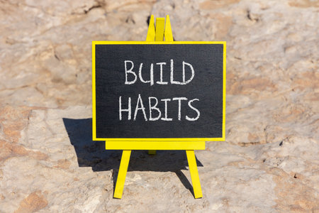 Build habits symbol. Concept word Build habits on beautiful black blackboard. Beautiful stone...